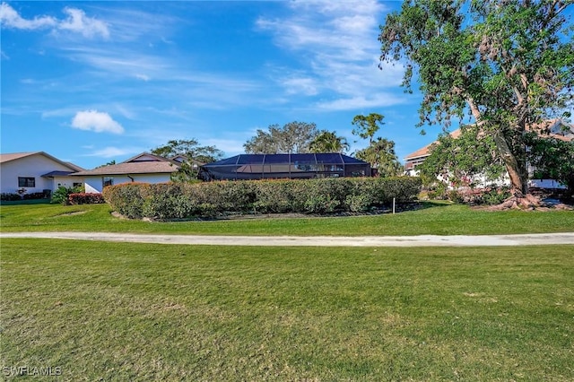 view of front of home featuring glass enclosure and a front yard