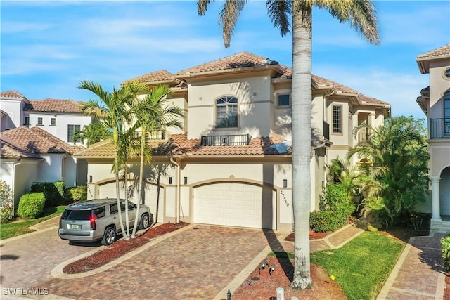 mediterranean / spanish home featuring a balcony and a garage