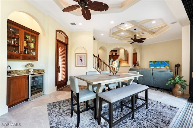 dining area with ornamental molding, ceiling fan, wine cooler, and coffered ceiling