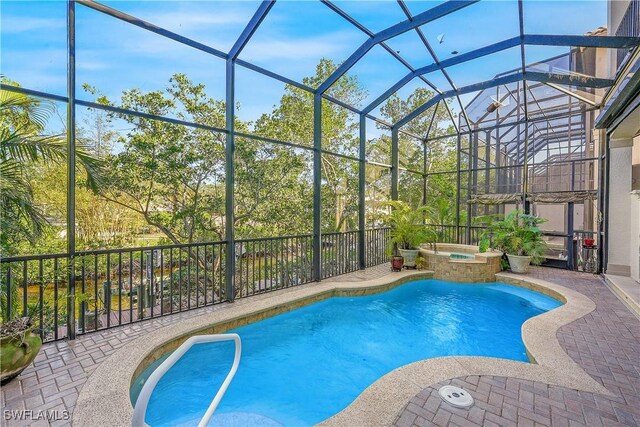 view of pool featuring a lanai, a patio, and an in ground hot tub