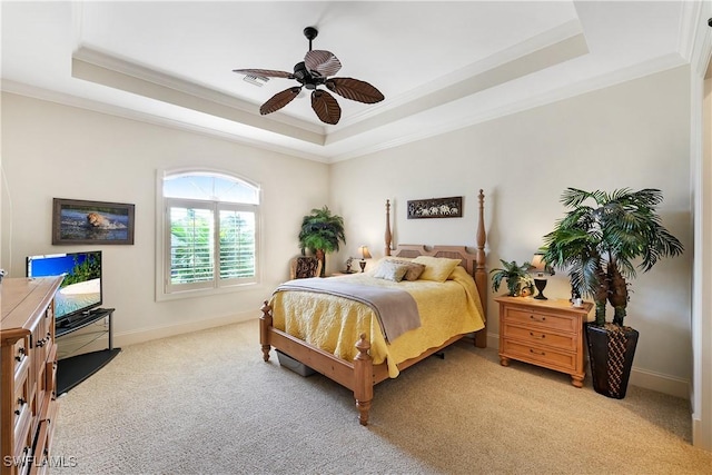 carpeted bedroom featuring a raised ceiling, ceiling fan, and crown molding