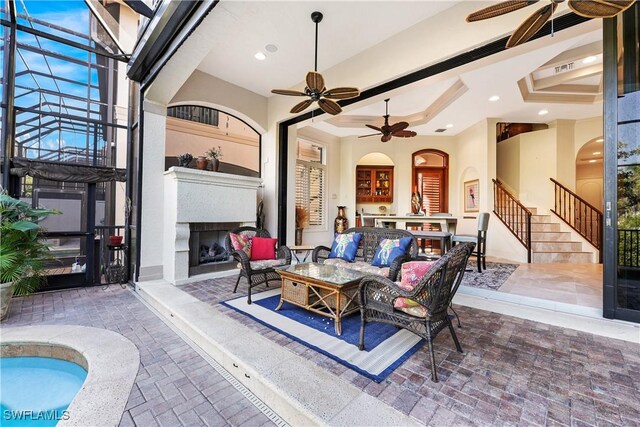 view of patio featuring ceiling fan and an outdoor living space with a fireplace