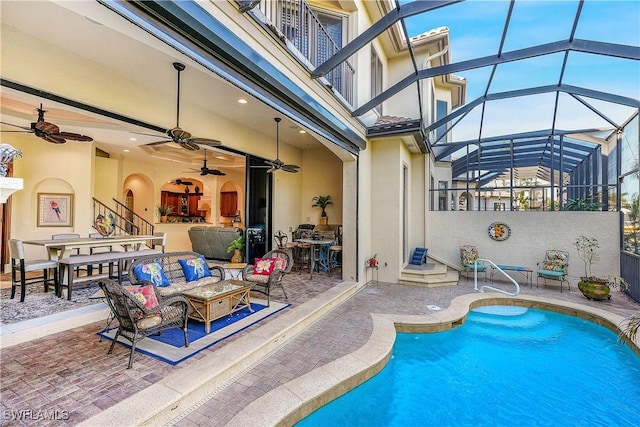 view of swimming pool with ceiling fan, a patio area, glass enclosure, and outdoor lounge area