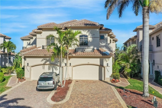 mediterranean / spanish house featuring a balcony and a garage