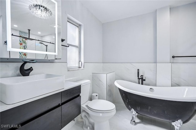 bathroom featuring a washtub, a notable chandelier, toilet, vanity, and tile walls