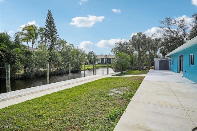 view of yard featuring a water view and a storage shed