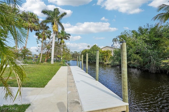 dock area featuring a lawn and a water view