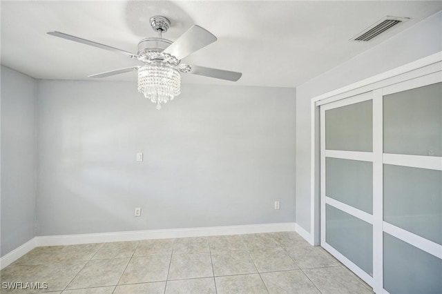 tiled empty room featuring ceiling fan