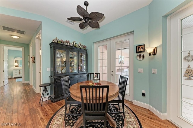 dining space with french doors, light wood-type flooring, and ceiling fan