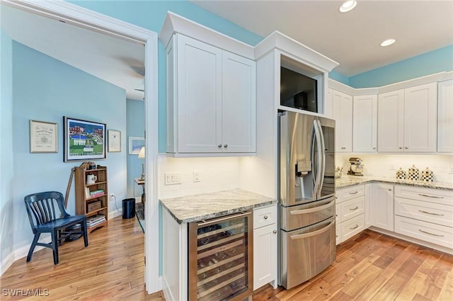 kitchen with white cabinetry, light stone countertops, beverage cooler, stainless steel fridge with ice dispenser, and light hardwood / wood-style floors