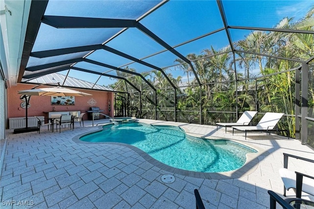 view of swimming pool featuring a lanai, a patio area, a grill, and an in ground hot tub