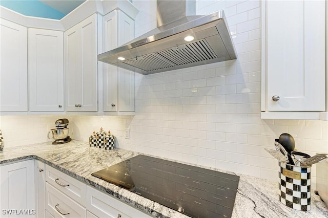 kitchen with backsplash, white cabinetry, and wall chimney exhaust hood