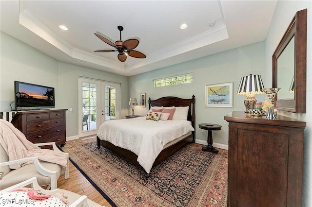 bedroom with access to outside, a raised ceiling, light hardwood / wood-style flooring, ceiling fan, and ornamental molding