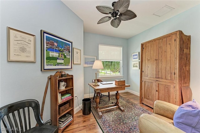 home office with light hardwood / wood-style floors and ceiling fan