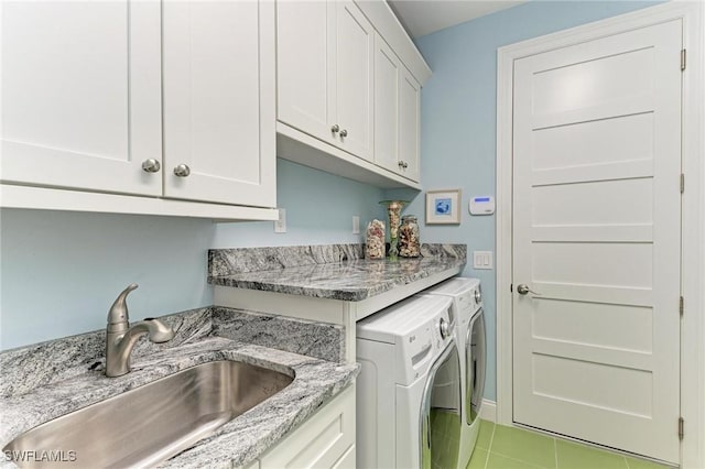 laundry room with cabinets, separate washer and dryer, light tile patterned flooring, and sink