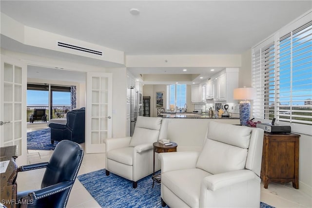 living area featuring french doors, light tile patterned floors, and healthy amount of natural light