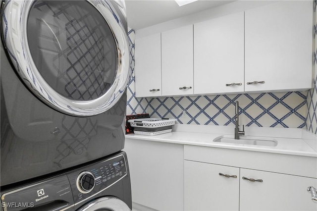 washroom with stacked washer and clothes dryer and cabinet space