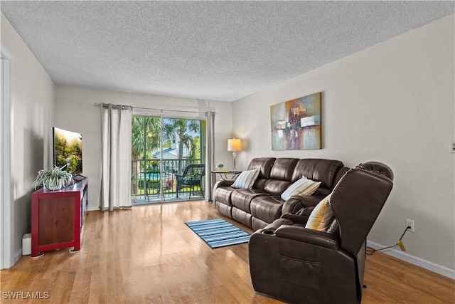 living room featuring light wood-type flooring and a textured ceiling