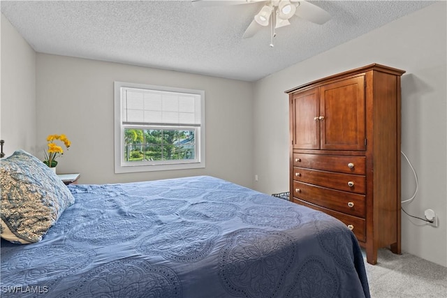 carpeted bedroom with ceiling fan and a textured ceiling