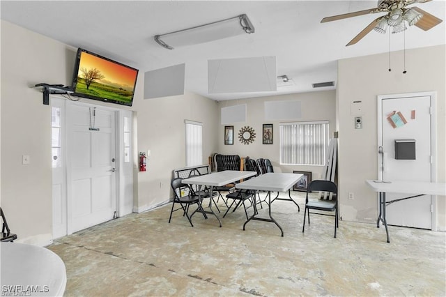 dining area with ceiling fan and concrete flooring