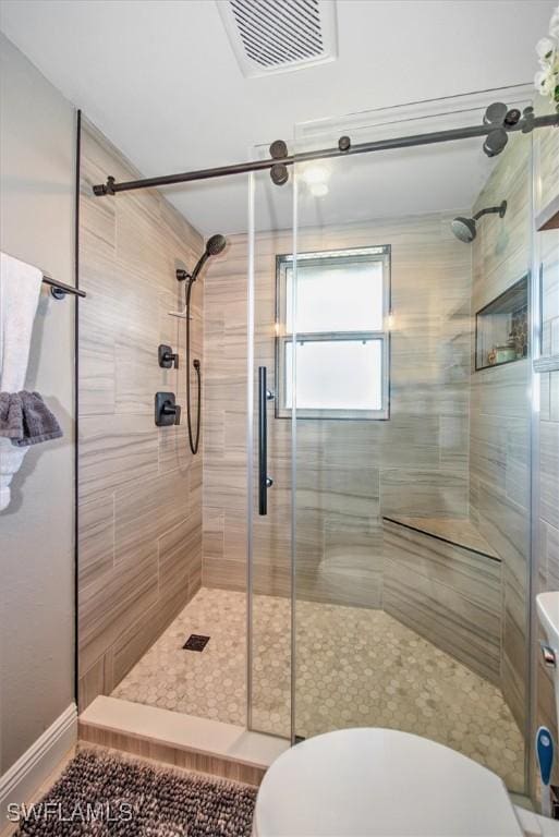 bathroom with toilet and a shower with shower door