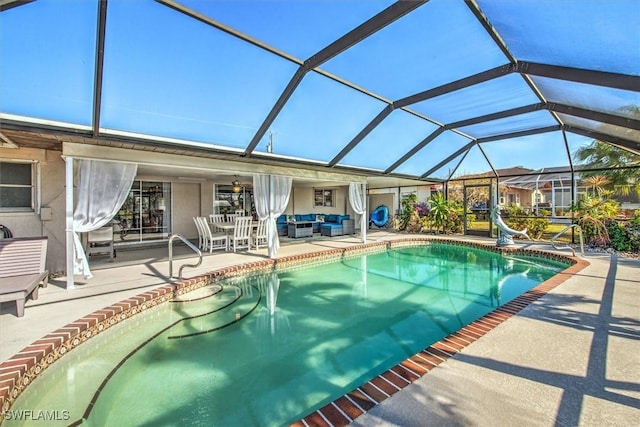 view of pool featuring a patio, glass enclosure, an outdoor hangout area, and ceiling fan