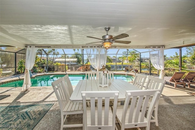 sunroom with ceiling fan, a swimming pool, and a healthy amount of sunlight