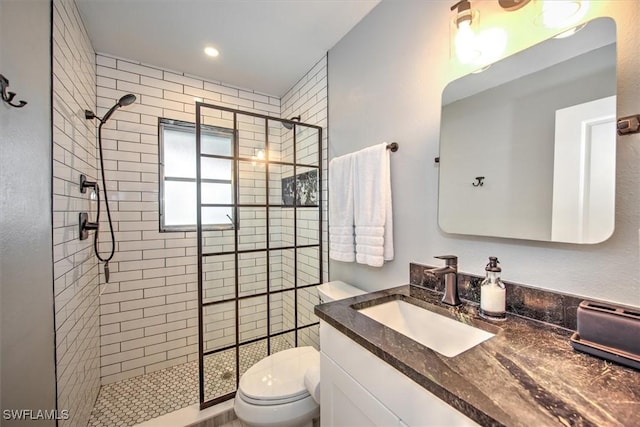 bathroom featuring tiled shower, vanity, and toilet