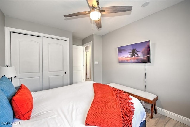 bedroom with hardwood / wood-style floors, a closet, and ceiling fan