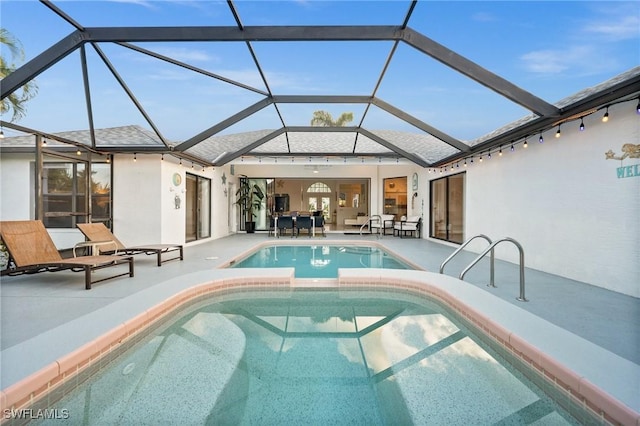 view of pool with glass enclosure and a patio area