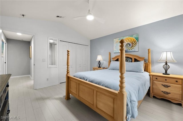 bedroom featuring light hardwood / wood-style flooring, a closet, lofted ceiling, and ceiling fan