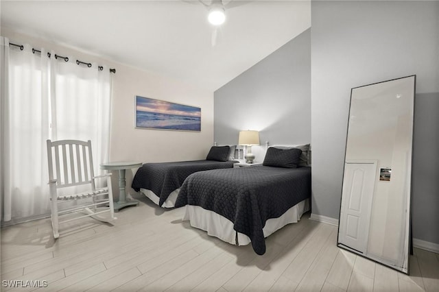 bedroom featuring ceiling fan, light wood-type flooring, and lofted ceiling