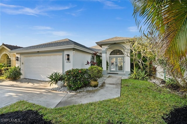 view of front of house featuring a front lawn, a garage, and french doors