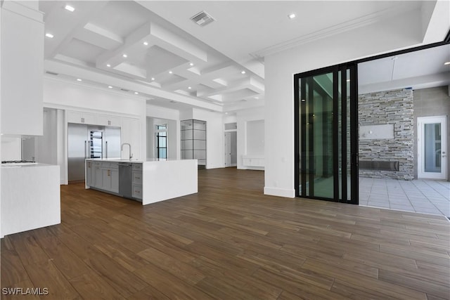 kitchen featuring a kitchen island with sink, dishwasher, white cabinets, and a high ceiling