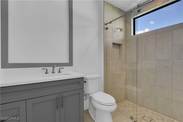 bathroom with tile patterned flooring, vanity, toilet, and a shower with shower door