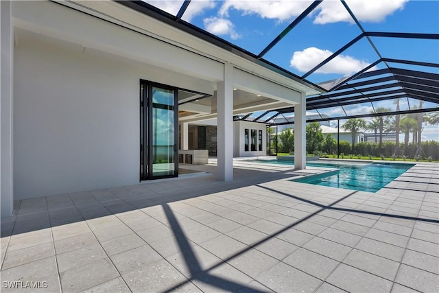 view of pool featuring glass enclosure and a patio area