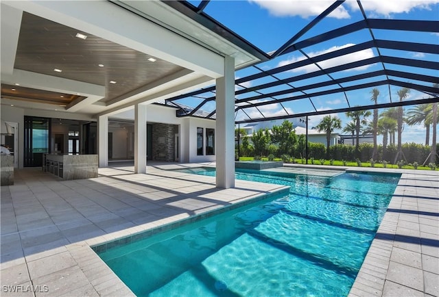 view of swimming pool featuring glass enclosure and a patio area