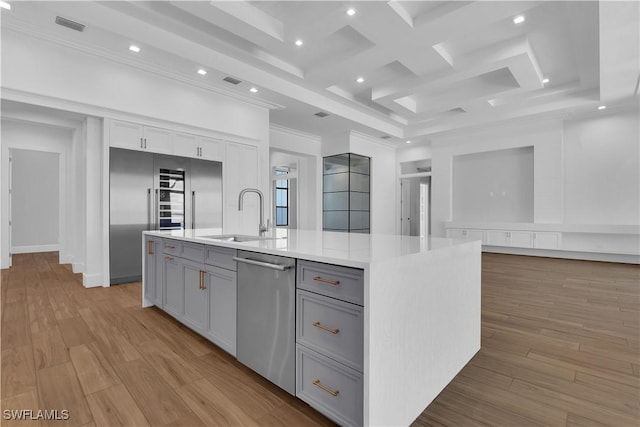 kitchen with stainless steel appliances, sink, light hardwood / wood-style flooring, gray cabinets, and an island with sink