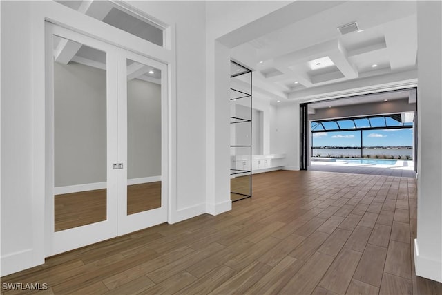 spare room featuring beam ceiling, french doors, and coffered ceiling