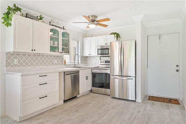 kitchen with backsplash, white cabinets, sink, ceiling fan, and appliances with stainless steel finishes