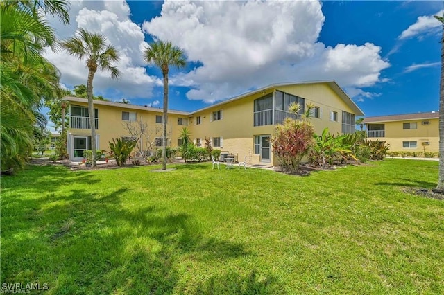 rear view of property with a yard