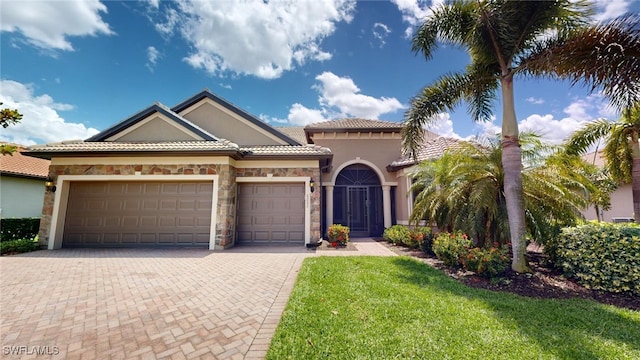 mediterranean / spanish home with a garage and a front lawn