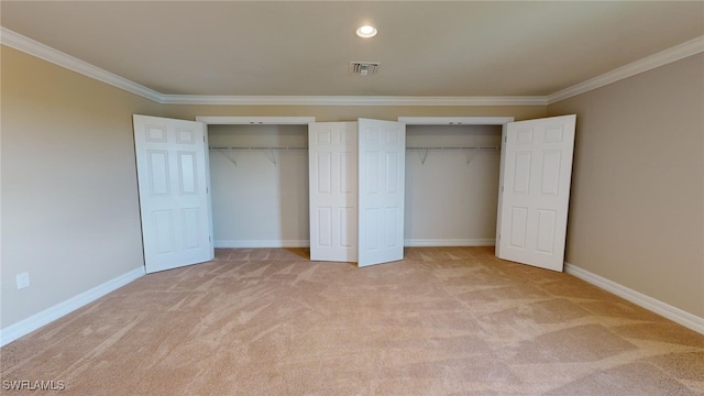 unfurnished bedroom featuring crown molding, light carpet, and multiple closets