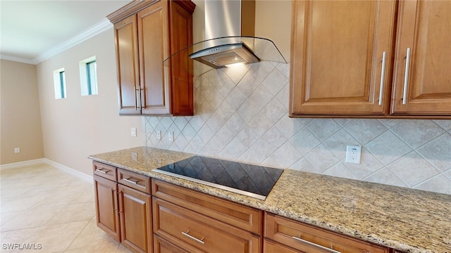 kitchen with light stone countertops, black electric stovetop, crown molding, and wall chimney exhaust hood