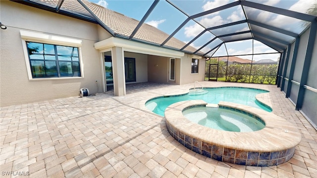 view of pool featuring a patio area, an in ground hot tub, and glass enclosure