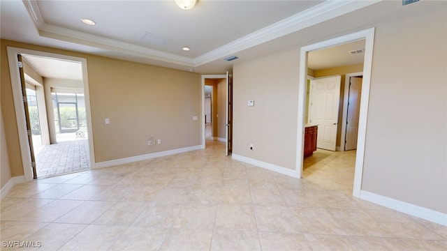 unfurnished room with a raised ceiling, light tile patterned floors, and ornamental molding