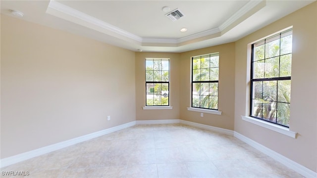 unfurnished room with a raised ceiling and crown molding