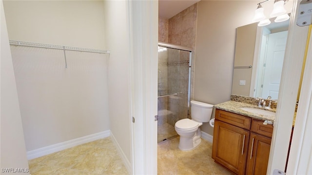 bathroom featuring tile patterned flooring, vanity, toilet, and a shower with shower door