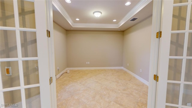 spare room with a tray ceiling and crown molding