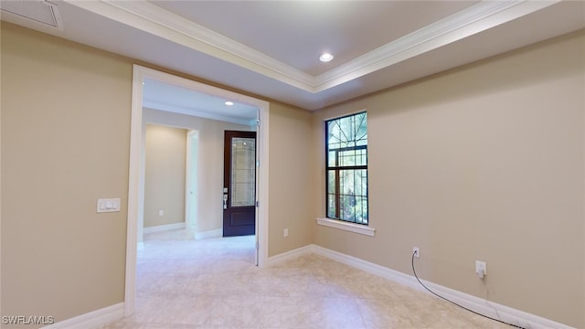 empty room with a raised ceiling and ornamental molding